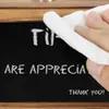 A hand is wiping a chalkboard with a white cloth. Text is visible on the chalkboard. Náhled obrázku produktu