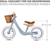 A light blue balance bike with a brown basket and seat, shown against a white background. Text overlays provide product information. Produktbild-Vorschau