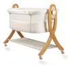 A baby bassinet on a wooden stand with wheels. Náhled obrázku produktu