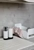 A kitchen sink area with a dish drying rack, soap dispenser, and cloth. Produktbild-Vorschau