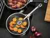 Two pans are on a stovetop, one with purple food and the other with orange food. Tongs are in the orange food pan. Produktbild-Vorschau