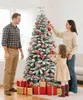 A family decorating a Christmas tree with presents underneath. Produktbild-Vorschau