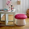 A child's room with a small table and a mushroom-shaped pouf. Produktbild-Vorschau