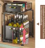 A two-tier pull-out organizer cabinet for kitchen and bathroom storage, filled with bottles of oil or sauce and canned goods. Produktbild-Vorschau