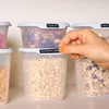 A hand is placing a label on a food storage container filled with oats. Produktbild-Vorschau