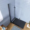 A modern shower enclosure with a black frame and glass panels, set against a light blue tiled wall and a wooden floor. Produktbild-Vorschau