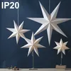 Several white paper star lanterns are displayed against a dark blue background. Some are hanging, while others are on stands. Produktbild-Vorschau
