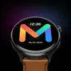 A close-up shot of a smartwatch with a colorful 'M' logo on its screen. Podgląd zdjęcia produktu