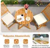 A wooden bistro set with two chairs and a table on a patio. Náhled obrázku produktu