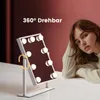 A woman is leaning on a table next to a makeup mirror with lights. Podgląd zdjęcia produktu