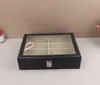A black glasses organizer with a clear lid sits on a white surface against a light brown background. Voir les images du produit