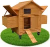 A wooden chicken coop with nesting boxes and a ramp, situated on a circular patch of green grass. Podgląd zdjęcia produktu