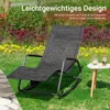 A rocking lounge chair is placed on a grassy lawn next to a small side table with a drink and a bottle. Podgląd zdjęcia produktu