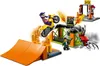 A LEGO stunt park playset with a motorcycle rider performing a jump, a large spider figure, and a stunt ramp. Podgląd zdjęcia produktu