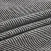 A close-up view of a grey herringbone patterned blanket. Anteprima dell’immagine prodotto