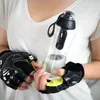 A person wearing workout gloves holds a water filter bottle. Anteprima dell’immagine prodotto