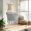 A hanging chair in a bright, airy room with a view of the ocean. Náhled obrázku produktu