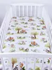A crib sheet with a woodland animal pattern is laid out inside a white crib. Produktbild-Vorschau