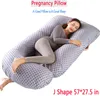 A woman is sleeping on a large, J-shaped pregnancy pillow. Náhled obrázku produktu