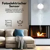 A living room scene with a sofa and a fireplace, featuring a smoke detector on the wall. Produktbild-Vorschau