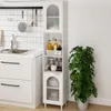 A tall, narrow white cabinet with glass doors and shelves, placed in a kitchen next to a sink and a large potted plant. Produktbild-Vorschau