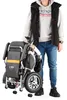 A person is standing next to a folded electric wheelchair. Náhľad obrázku produktu