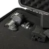 A camera is placed inside a black protective case with foam padding. Produktbild-Vorschau
