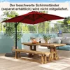 An outdoor patio scene with a wooden table, benches, and a red umbrella. Náhled obrázku produktu