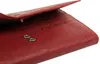 A close-up view of the interior of a red leather wallet, showing snap closures and embossed branding. Produktbild-Vorschau