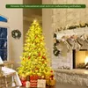 A decorated Christmas tree with presents underneath, next to a fireplace with stockings hung. Podgląd zdjęcia produktu