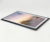 A framed picture of a beach scene with a bird flying over sand dunes at sunset, placed on a white surface. Produktbild-Vorschau