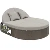 A round outdoor daybed with a woven base and light gray cushions, featuring two pillows and a small attached side table with drinks. Podgląd zdjęcia produktu