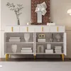 A white sideboard with gold handles is displayed in a room, showcasing its interior shelves and decorative items. Produktbild-Vorschau