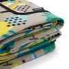 A folded picnic blanket with a tropical pattern. Produktbild-Vorschau