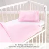 A pink duvet cover and pillowcase are laid out in a white crib. Produktbild-Vorschau