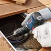 A person wearing work gloves is using a Bosch cordless drill to drill into a wooden deck. Náhled obrázku produktu