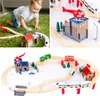 A collage of images showing a child playing with a wooden train set, close-ups of the train set components, and a full view of the assembled train track with various accessories. Náhled obrázku produktu