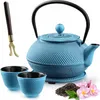 A blue cast iron teapot set with two cups, a tea scoop, and loose tea leaves with flowers. Náhled obrázku produktu