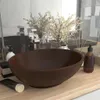 A bathroom countertop with a dark brown ceramic sink, soap dispenser, and decorative plants. Podgląd zdjęcia produktu