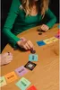 People playing a card game on a wooden table. Produktbild-Vorschau