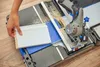 A person is using a DREMEL Blueprint Mobile Saw Station to cut a piece of white molding. Produktbild-Vorschau