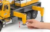 A hand is shown adjusting the support leg of a toy crane truck. Náhľad obrázku produktu