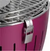A close-up view of a purple charcoal grill, focusing on the lid latch and the stainless steel grill grate. Produktbild-Vorschau