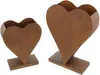 Two heart-shaped planters with a rustic, rusted metal appearance, standing on rectangular bases. Voir les images du produit