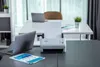 A Brother ADS-4300N document scanner is shown on a desk with a laptop and documents. Voir les images du produit