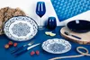 A table setting with blue and white patterned plates, a blue wine glass, a blue tumbler, a blue bowl, cutlery, strawberries, raspberries, lemon slices, and a rope. Anteprima dell’immagine prodotto