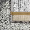 Close-up view of the edge and underside of a rug with an abstract pattern. Produktbild-Vorschau