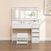 A white vanity table with a stool and drawers, set against a light pink wall. Produktbild-Vorschau