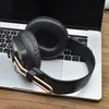 A pair of black headphones rests on a silver laptop keyboard. Voir les images du produit
