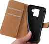 A hand holding a black phone case, showing the inside of a brown flip cover case with card slots. Produktbild-Vorschau